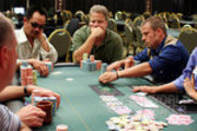 Mike McClain (center) looks on as Joe Sebok (right) bets 200,000 against David Pham (left).