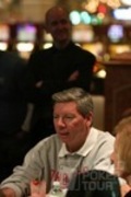 World Poker Tour CEO Steve Lipscomb (standing) checks on the progress of Mike Sexton on Day 2 of the WPT Doyle Brunson Five Diamond World Poker Classic