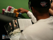 Phil Ivey reads an article about his recent WPT title while playing on Day 2 of the WPT Reno World Poker Challenge