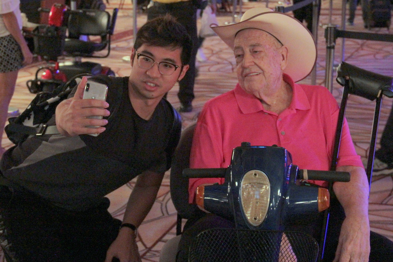 A fan grabs a selfie with Doyle Brunson